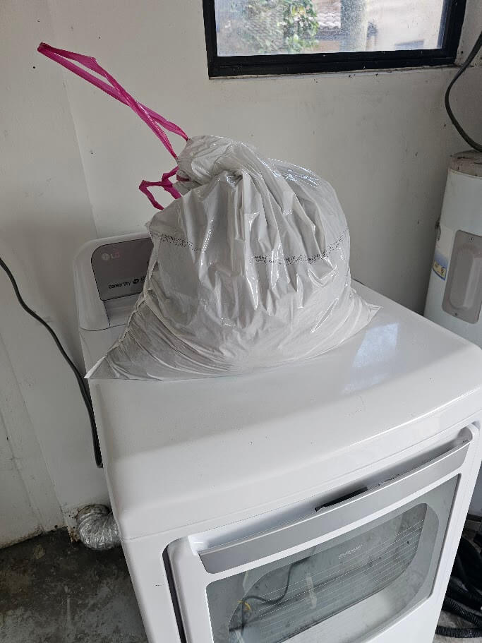 Dryer lint pulled from a dryer vent filling an entire trash bag